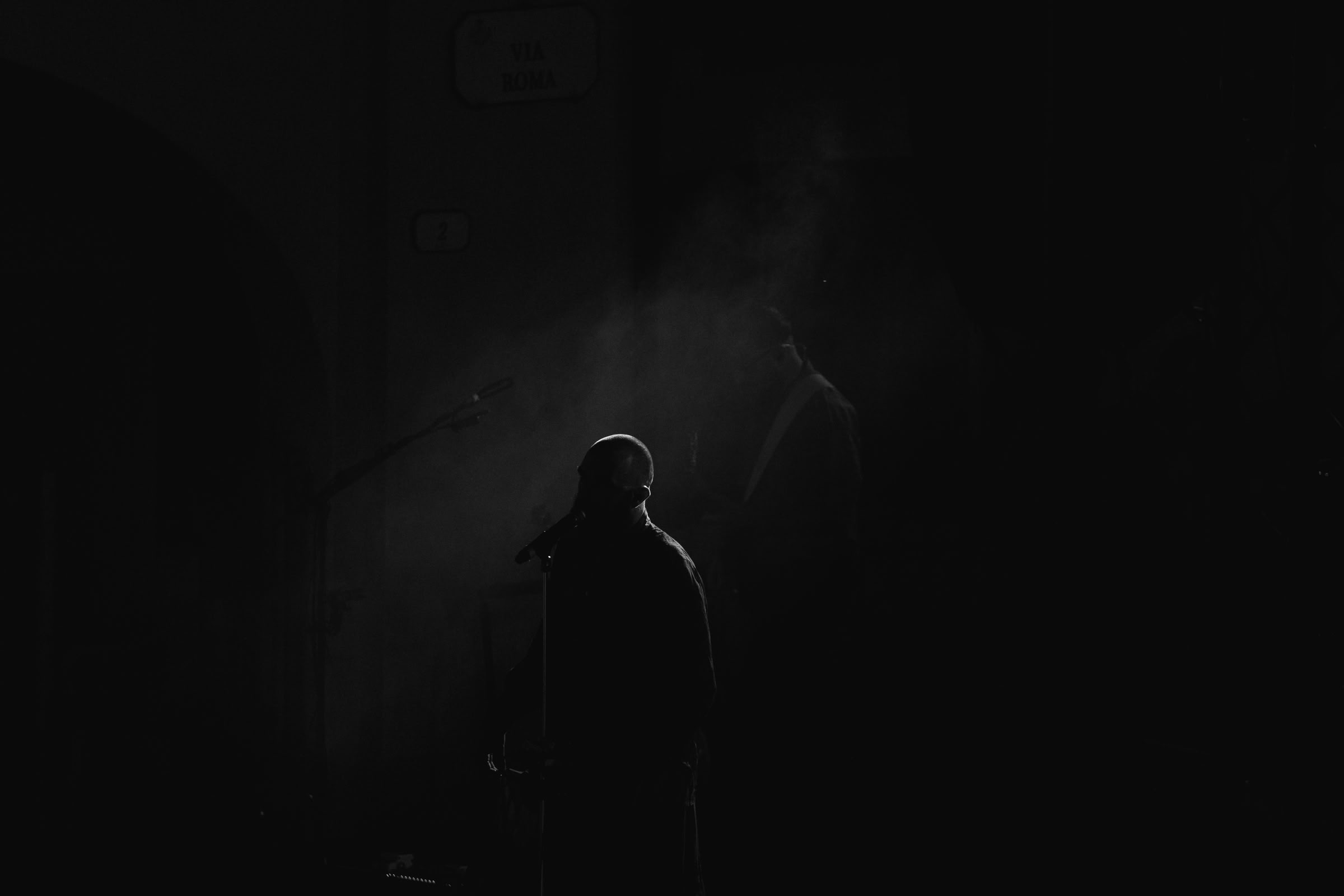 Silhouette del cantante dal retro — fumo e luci di scena